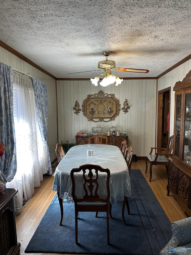 dining area featuring ornamental molding, a textured ceiling, and wood finished floors