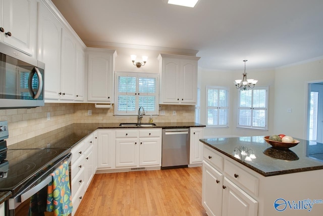 102 Twin Island Cir, Madison, AL 35758 - kitchen with appliances with stainless steel finishes, a sink, a chandelier, decorative backsplash, and dark stone counters