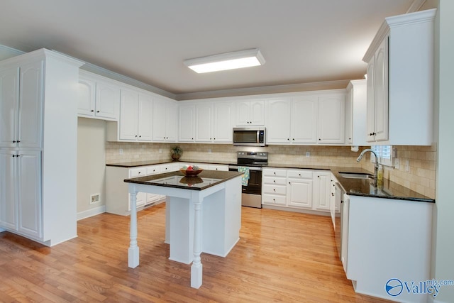 102 Twin Island Cir, Madison, AL 35758 - kitchen featuring stainless steel appliances, a sink, decorative backsplash, and light wood-style floors