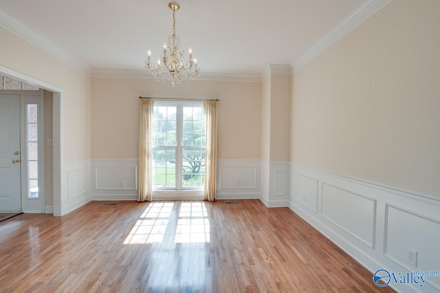102 Twin Island Cir, Madison, AL 35758 - unfurnished room with a chandelier, light wood finished floors, a wainscoted wall, a decorative wall, and ornamental molding