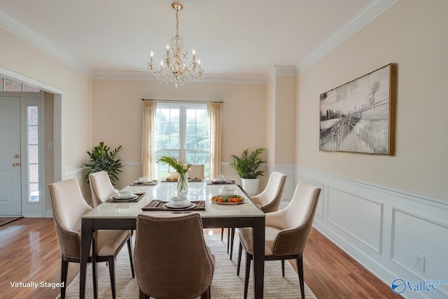 102 Twin Island Cir, Madison, AL 35758 - dining room with a chandelier, wood finished floors, crown molding, a wainscoted wall, and a decorative wall