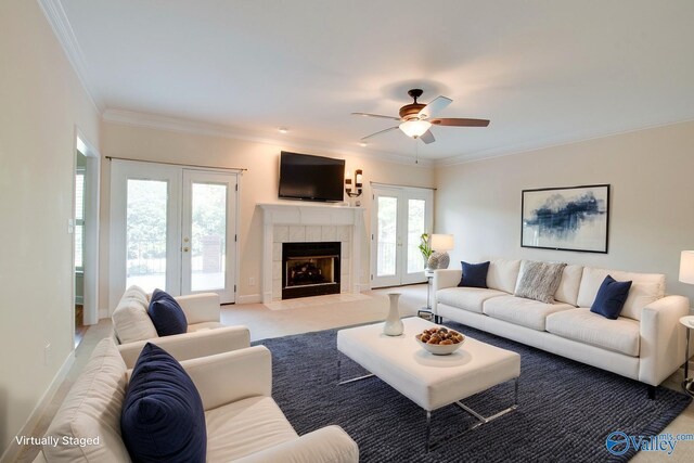 102 Twin Island Cir, Madison, AL 35758 - living room with french doors, ceiling fan, crown molding, a tiled fireplace, and light colored carpet