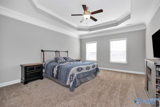 bedroom featuring crown molding, a tray ceiling, carpet flooring, and baseboards