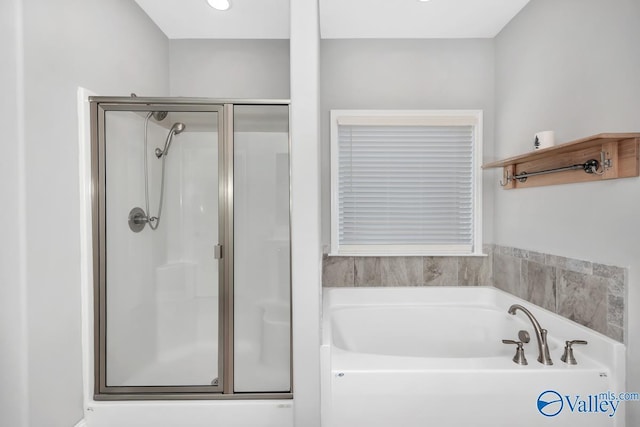 bathroom with a stall shower and a garden tub