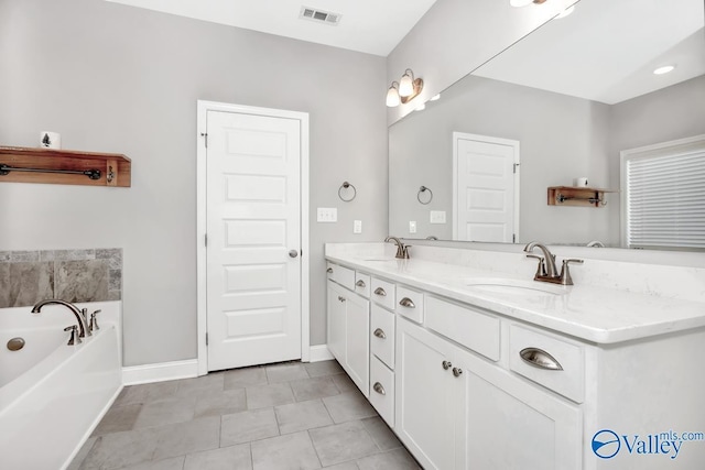 full bath featuring double vanity, a sink, visible vents, and baseboards