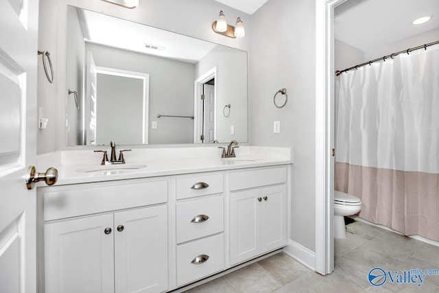 bathroom featuring visible vents, a sink, toilet, and double vanity