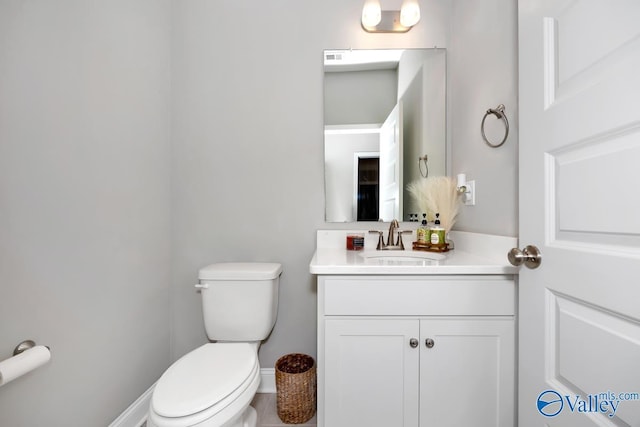 bathroom with baseboards, vanity, and toilet