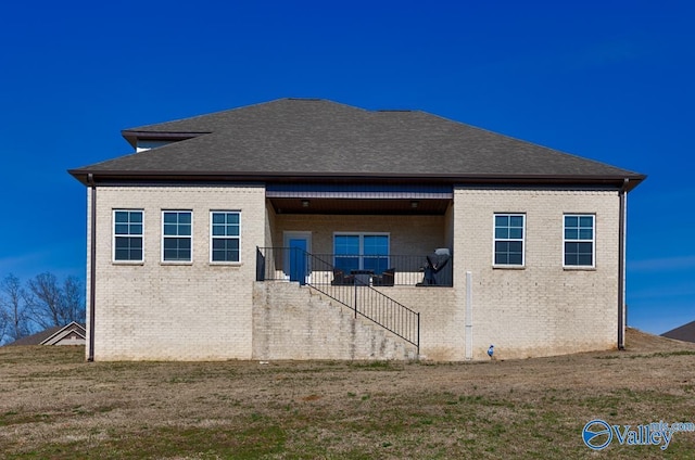 view of property exterior with brick siding, stairway, and a shingled roof