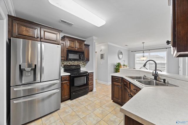 kitchen with visible vents, a sink, light countertops, black appliances, and ornamental molding