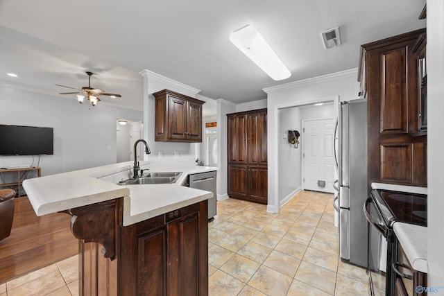 kitchen featuring crown molding, open floor plan, ceiling fan, a sink, and appliances with stainless steel finishes
