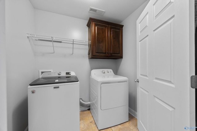 washroom featuring visible vents, washer and clothes dryer, cabinet space, and baseboards