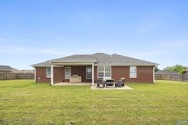 back of house with brick siding, a fenced backyard, a patio area, and a yard