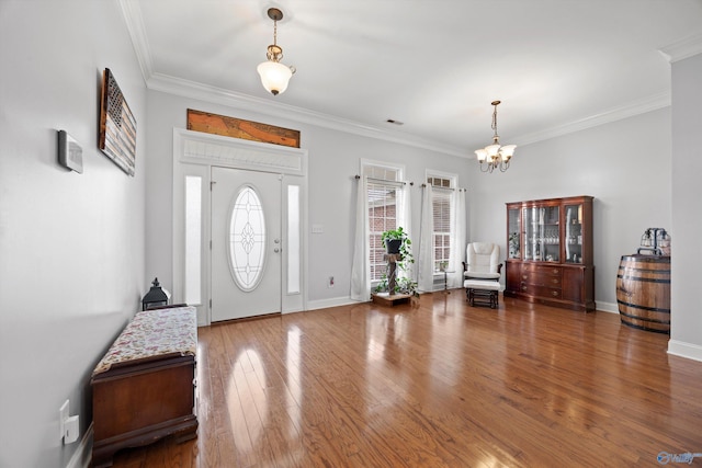 entryway featuring crown molding, plenty of natural light, wood finished floors, and a notable chandelier