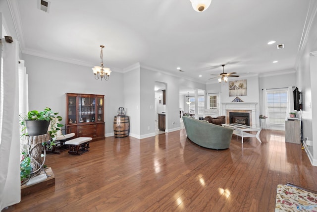 living room with a fireplace, ceiling fan with notable chandelier, wood finished floors, and visible vents