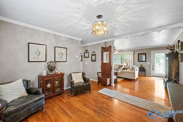 living area featuring baseboards, ornamental molding, and wood finished floors