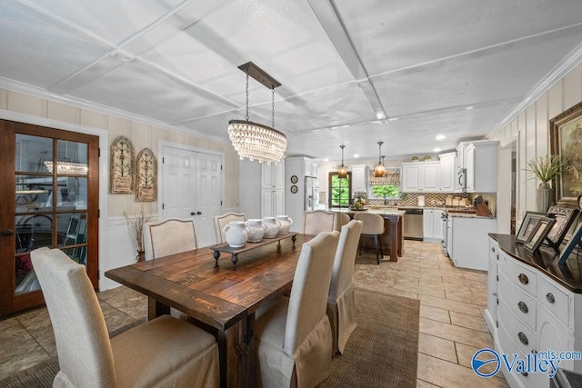 dining area with an inviting chandelier and ornamental molding