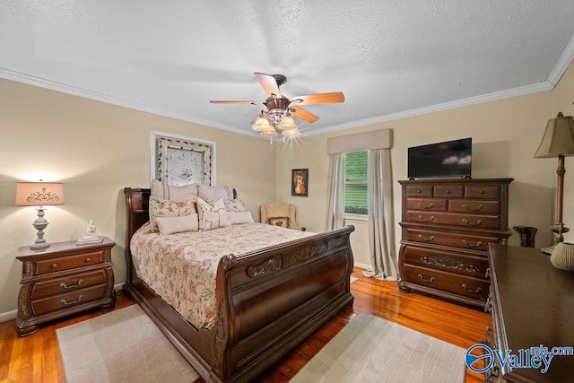 bedroom with ornamental molding, ceiling fan, and wood finished floors