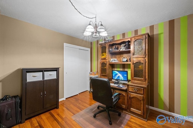 office featuring baseboards, a chandelier, and wood finished floors
