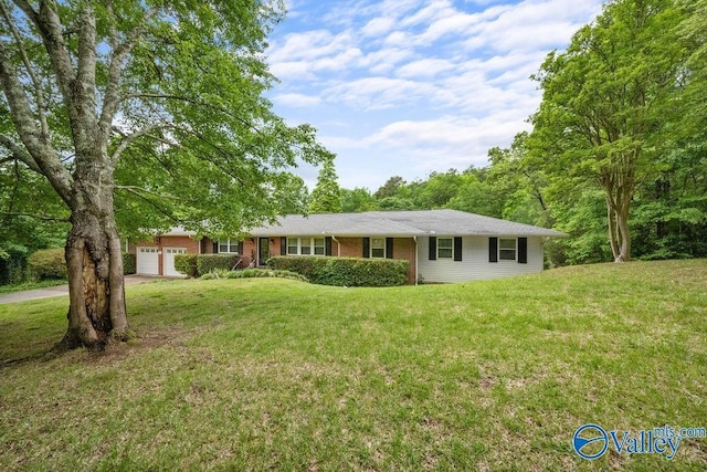 ranch-style house featuring an attached garage, concrete driveway, brick siding, and a front lawn