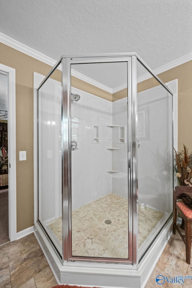 full bathroom with a shower stall, ornamental molding, and a textured ceiling