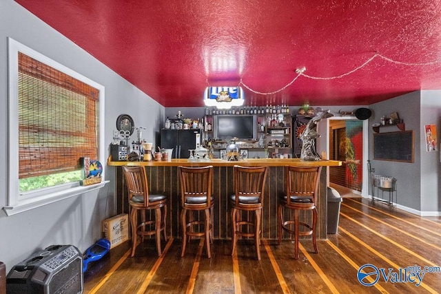 bar with freestanding refrigerator, hardwood / wood-style floors, and a dry bar