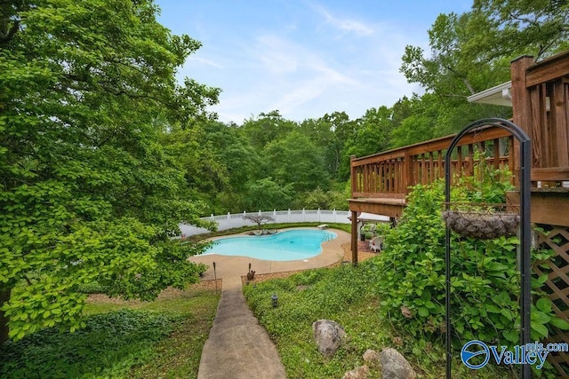 view of swimming pool featuring a fenced backyard, a wooden deck, and a fenced in pool