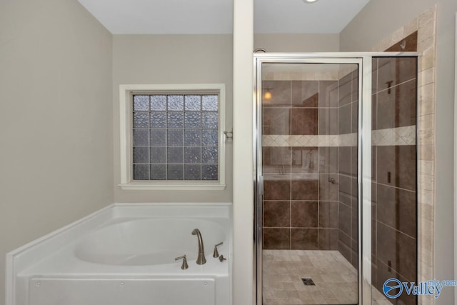 bathroom with a shower stall and a bath