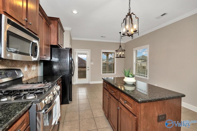 kitchen with stainless steel appliances, tasteful backsplash, visible vents, ornamental molding, and a chandelier