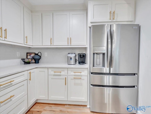 1901 Governors Dr SE, Huntsville, AL 35801 - kitchen featuring stainless steel fridge, light countertops, white cabinets, tasteful backsplash, and light wood-style floors