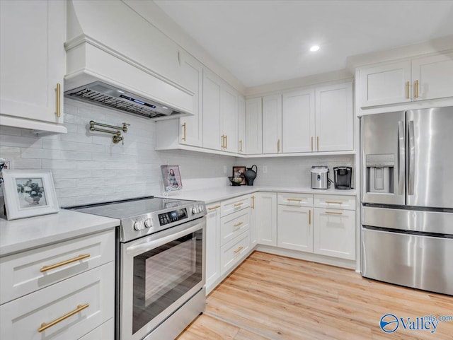1901 Governors Dr SE, Huntsville, AL 35801 - kitchen featuring appliances with stainless steel finishes, light countertops, custom exhaust hood, white cabinets, and recessed lighting