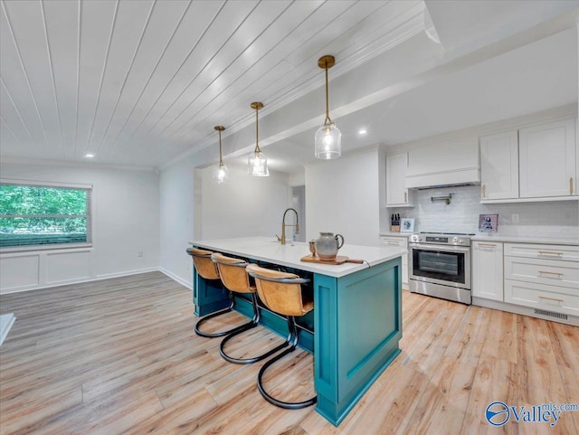 1901 Governors Dr SE, Huntsville, AL 35801 - kitchen featuring stainless steel range with electric cooktop, ornamental molding, light countertops, white cabinets, and light wood-type flooring