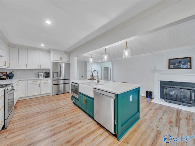 1901 Governors Dr SE, Huntsville, AL 35801 - kitchen featuring appliances with stainless steel finishes, white cabinetry, a fireplace with raised hearth, light countertops, and recessed lighting
