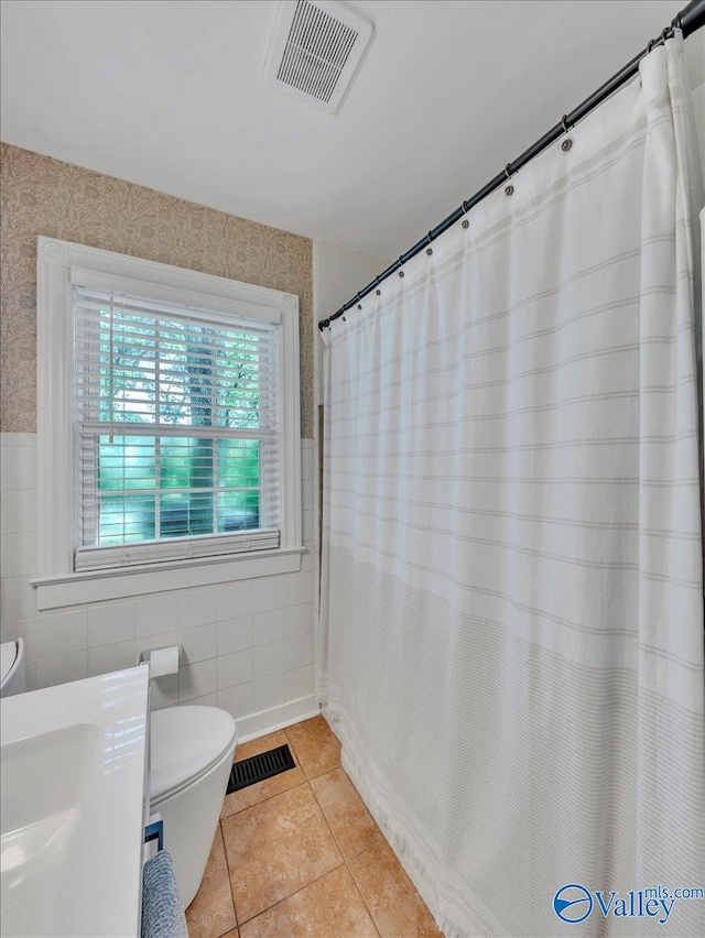 1901 Governors Dr SE, Huntsville, AL 35801 - bathroom with tile patterned floors, tile walls, a shower with shower curtain, wallpapered walls, and wainscoting