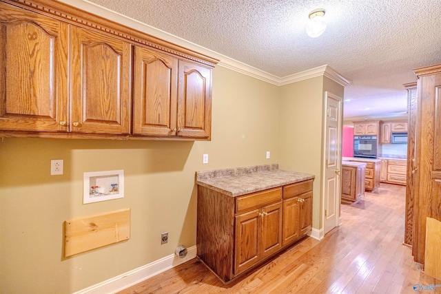 clothes washing area with cabinet space, hookup for an electric dryer, light wood-style flooring, and washer hookup