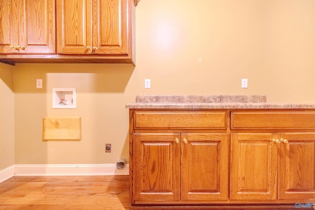 laundry room with light wood-type flooring, washer hookup, cabinet space, baseboards, and hookup for an electric dryer