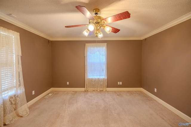 unfurnished room with visible vents, a textured ceiling, carpet, crown molding, and baseboards