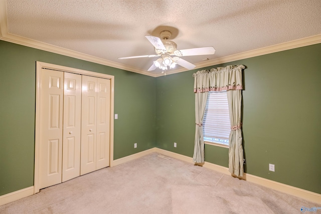 unfurnished bedroom featuring baseboards, crown molding, and carpet