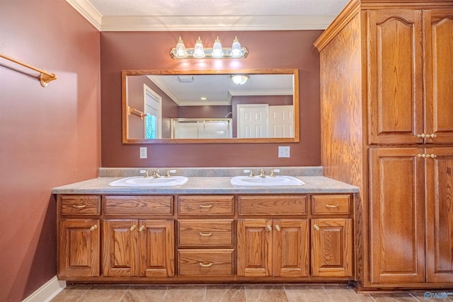 bathroom with an enclosed shower, ornamental molding, and a sink