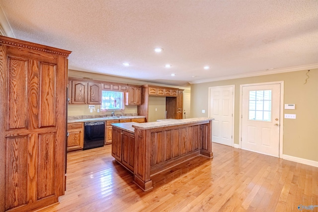 kitchen featuring light wood finished floors, a center island, black dishwasher, and ornamental molding
