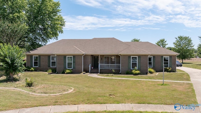 single story home featuring covered porch, brick siding, and a front yard