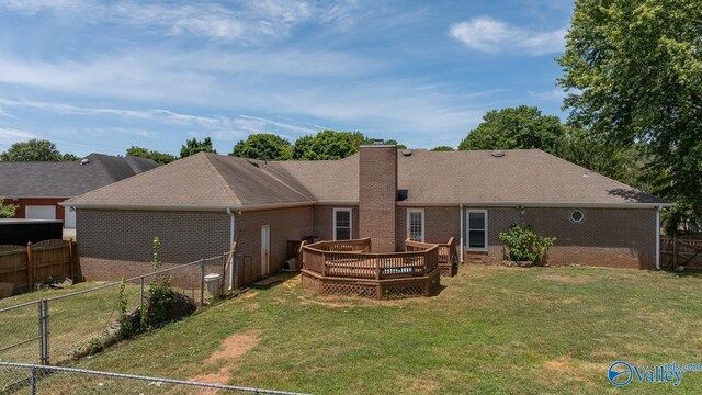 rear view of house featuring a deck and a lawn