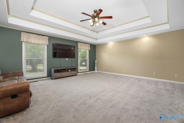 unfurnished living room with a raised ceiling and a healthy amount of sunlight