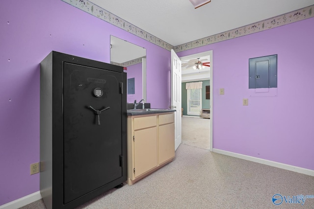 kitchen featuring electric panel, light carpet, baseboards, and a ceiling fan