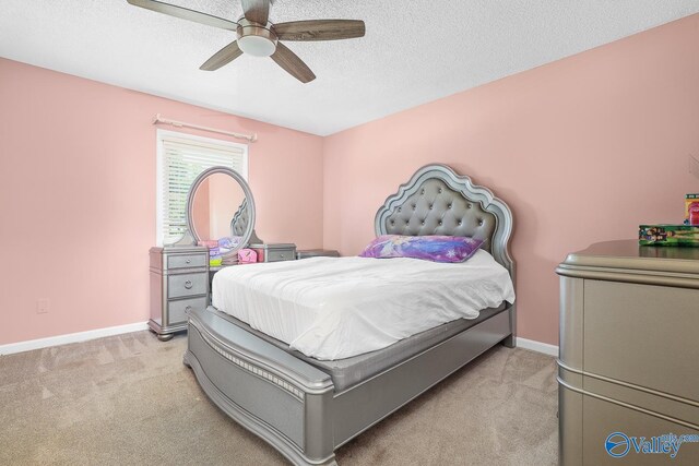 carpeted bedroom featuring a textured ceiling and ceiling fan