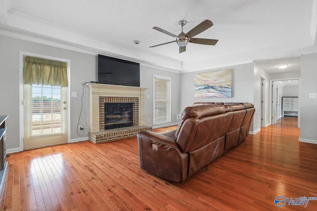 living area featuring ornamental molding, a ceiling fan, and wood-type flooring