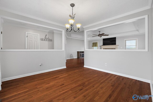 empty room with ornamental molding, ceiling fan with notable chandelier, hardwood / wood-style floors, and a tray ceiling