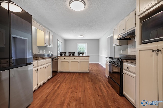 kitchen with hardwood / wood-style floors, sink, dishwasher, black range with electric stovetop, and kitchen peninsula