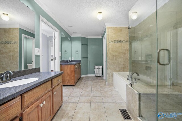 full bathroom featuring ornamental molding, dual vanity, tile patterned floors, and a textured ceiling