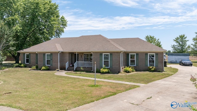 ranch-style home with covered porch, concrete driveway, brick siding, and a front yard