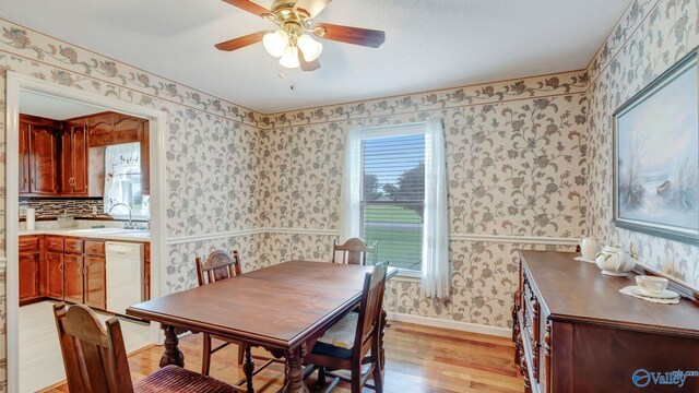565 Joe Quick Rd, Hazel Green, AL 35750 - dining area featuring wallpapered walls, light wood finished floors, ceiling fan, and baseboards